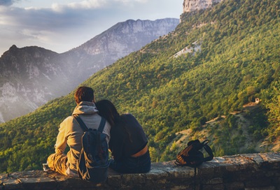 couple sitting while looking at the mountain